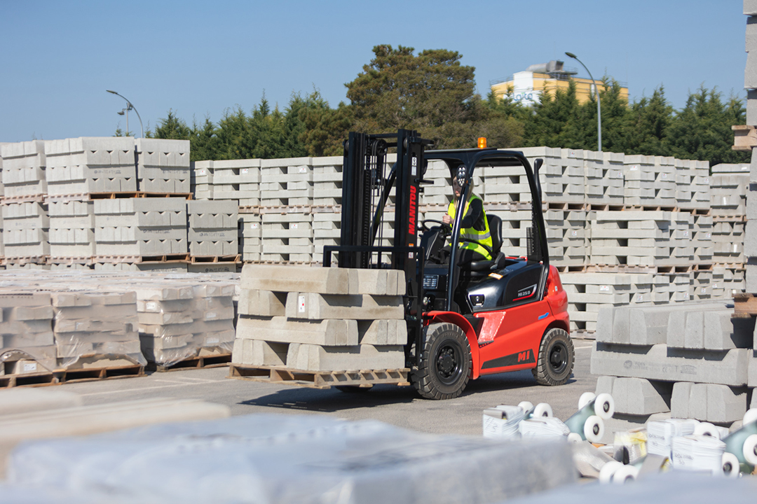 Manitou forklift moving concrete blocks in a yard